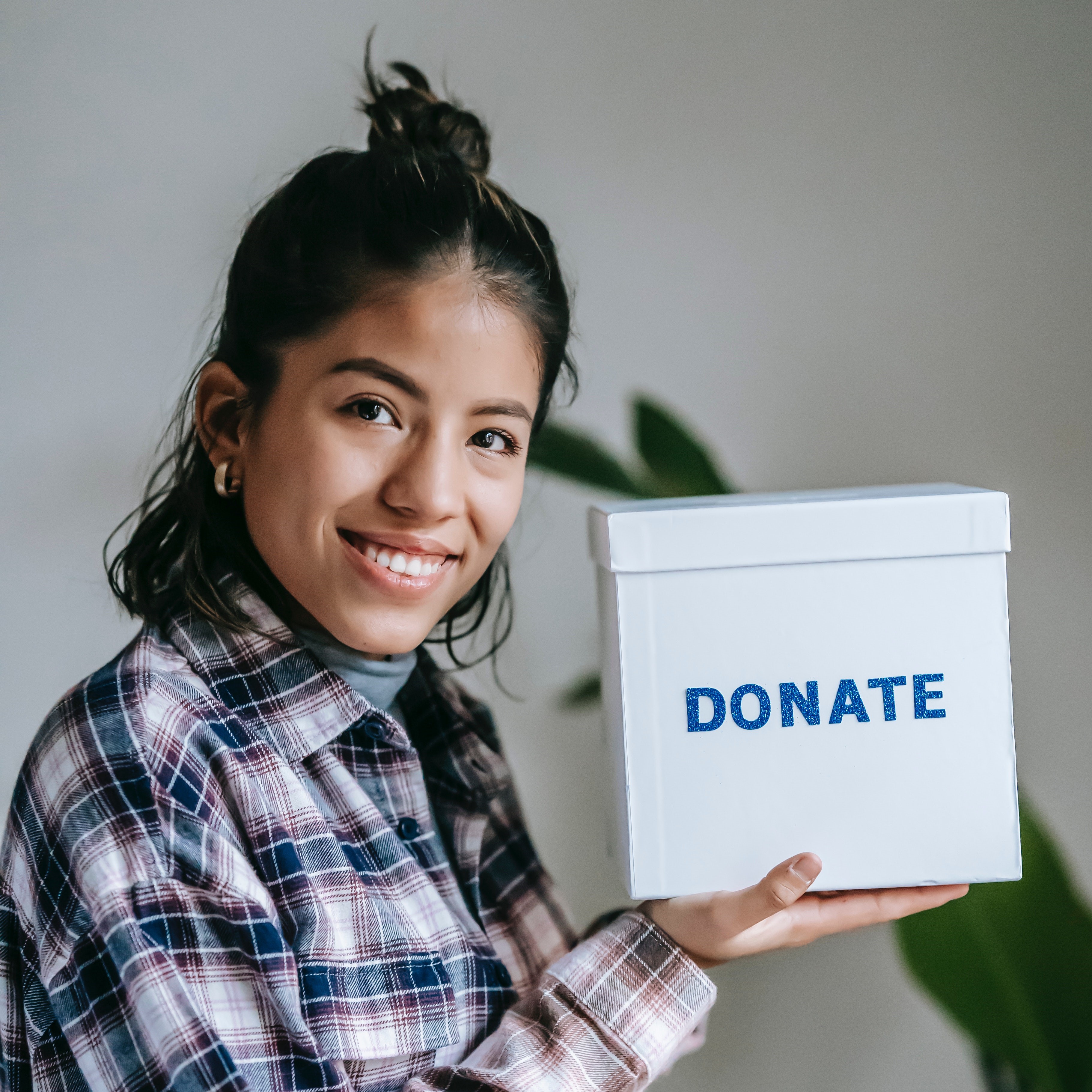 A person holding the box that says "Donate"